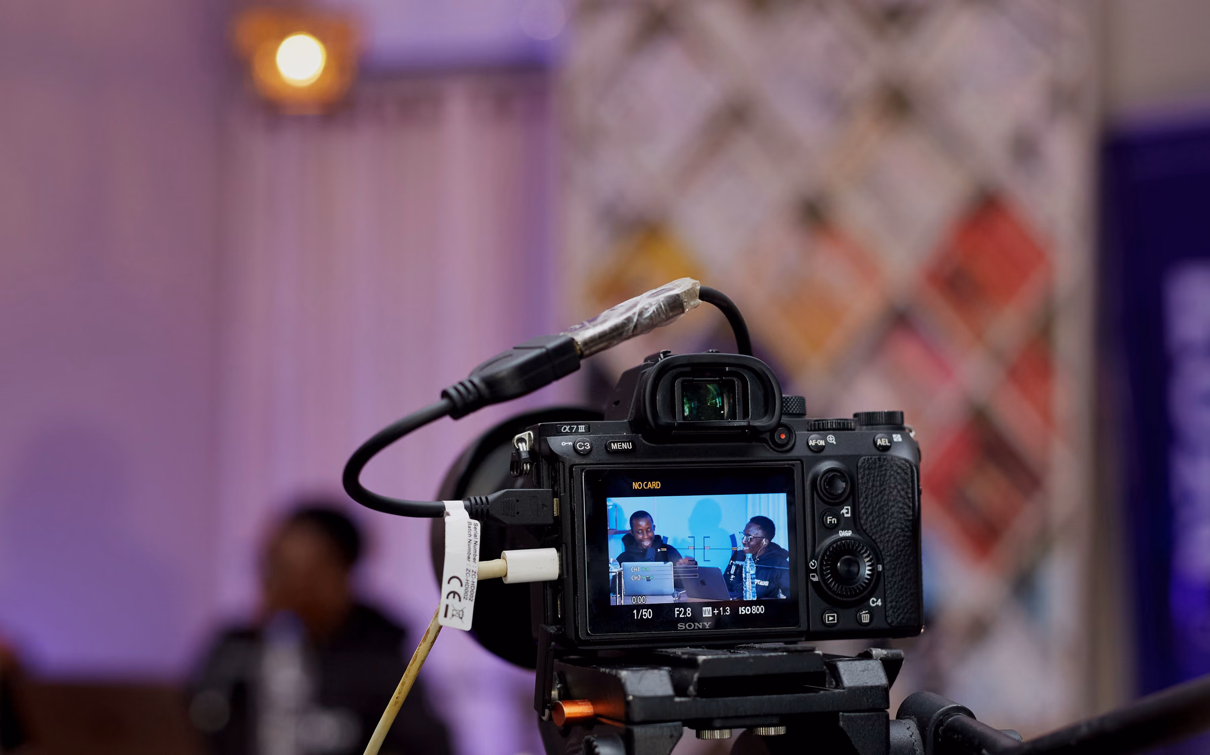 Camera on a tripod framing a conference session